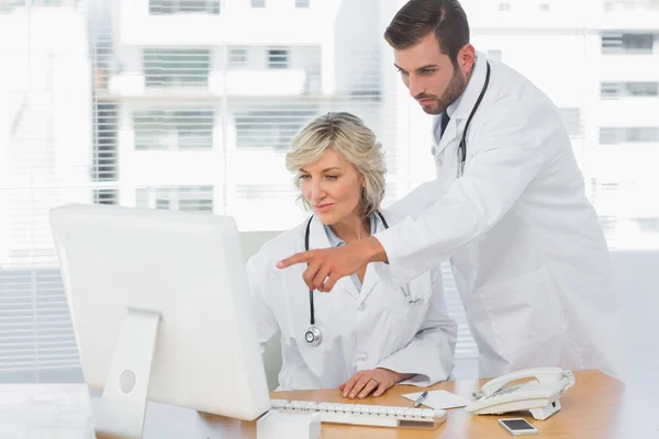 Läkare använder dator på läkarmottagning — Stockfoto
