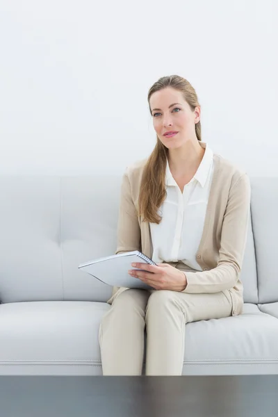 Seriöse Finanzberaterin sitzt auf Sofa — Stockfoto