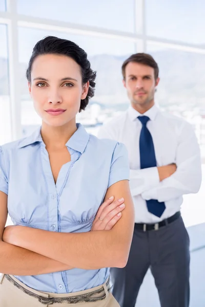 Ernstige zakenvrouw met mannelijke collega op achtergrond — Stockfoto