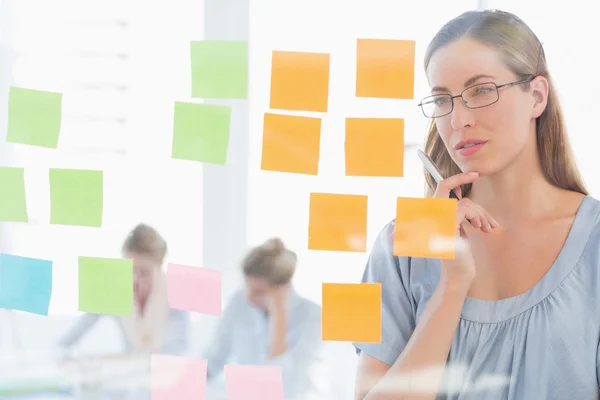 Concentrated artist looking at colorful sticky notes — Stock Photo, Image