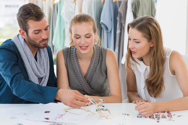 Tres diseñadores de moda discutiendo diseños — Foto de Stock