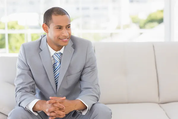 Biznesmen uśmiechający się siedząc na kanapie — Zdjęcie stockowe