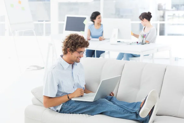 Man använder laptop med kollegor på creative office — Stockfoto