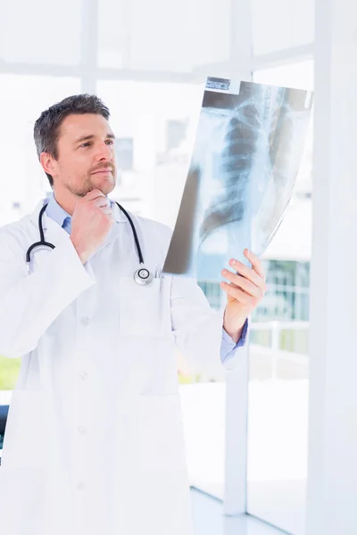 Médico masculino serio examinando rayos X — Foto de Stock