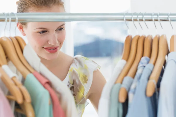 Cliente femenino seleccionando ropa en la tienda — Foto de Stock