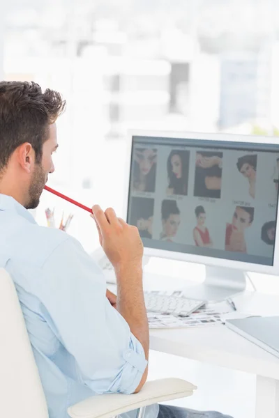 Éditeur photo masculin travaillant sur ordinateur dans le bureau — Photo