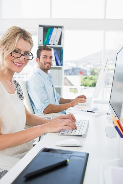 Smiling casual young couple working on computer — Stock Photo, Image