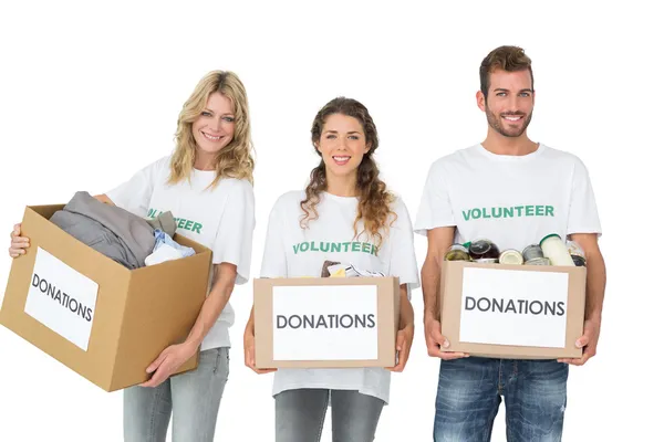 Porträtt av tre leende ungdomar med donation lådor — Stockfoto