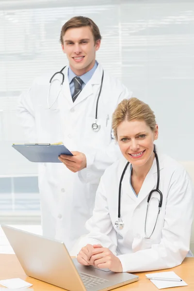 Doctors smiling at the camera together — Stock Photo, Image