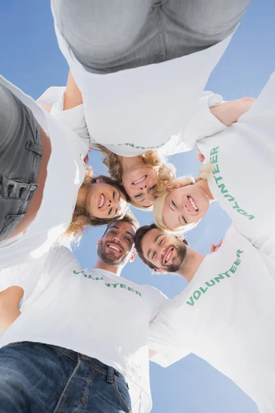 Happy volunteers forming a huddle against blue sky — Stock Photo, Image