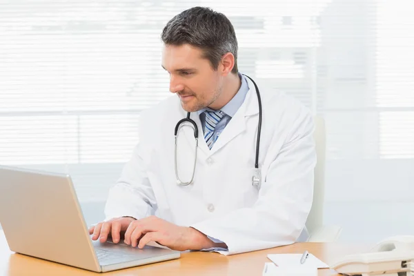 Врач, работающий на ноутбуке в медицинском кабинете — стоковое фото
