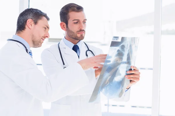 Doctors examining x-ray in medical office — Stock Photo, Image