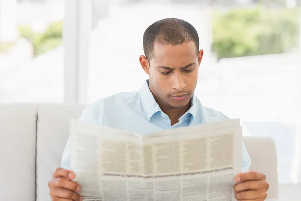 Uomo d'affari che legge il giornale sul divano — Foto Stock