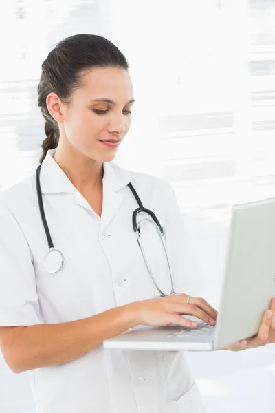 Doctora joven concentrada usando laptop — Foto de Stock