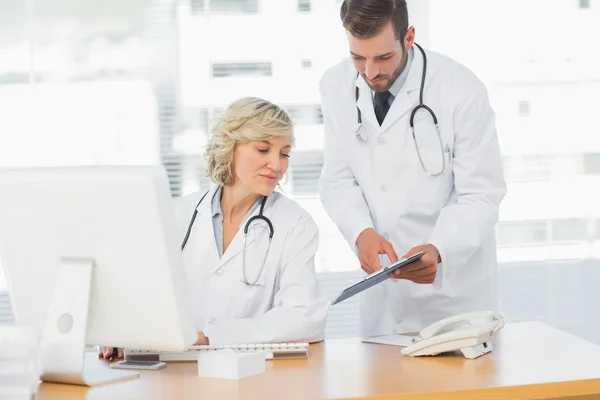 Artsen met behulp van digitale Tablet PC bij medische kantoor — Stockfoto