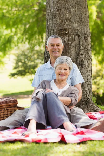 Senior man embracing woman from behind at park — Stock Photo, Image