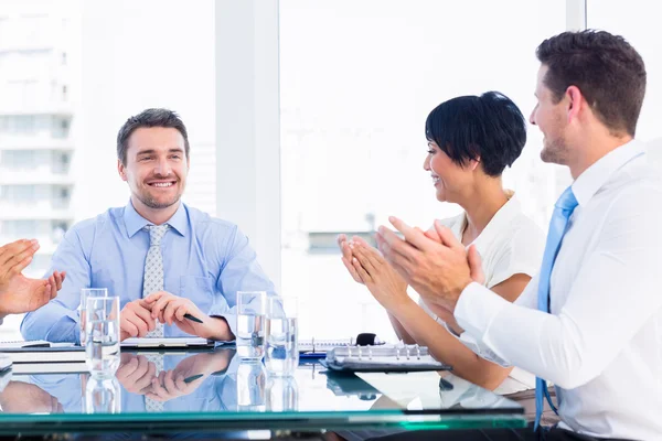 Executivos batendo palmas em torno da mesa de conferência — Fotografia de Stock