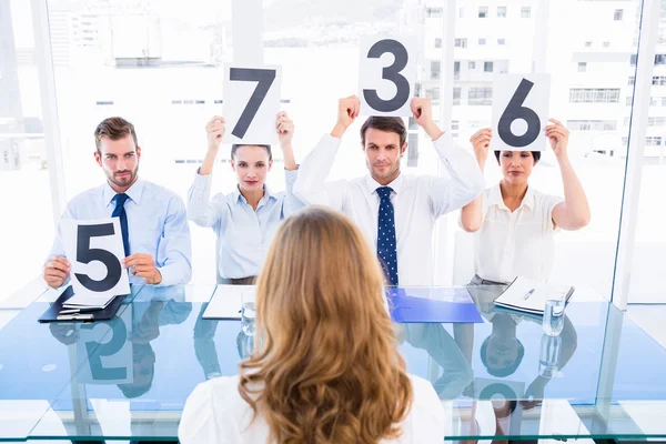 Grupo de jueces del panel con signos de puntuación delante de la mujer — Foto de Stock