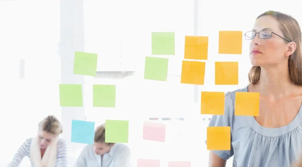 Concentrated artist looking at colorful sticky notes — Stock Photo, Image