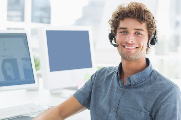 Smiling casual man with headset in the office — Stock Photo, Image