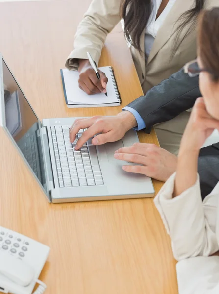Коллеги по бизнесу используют ноутбук в офисе — стоковое фото