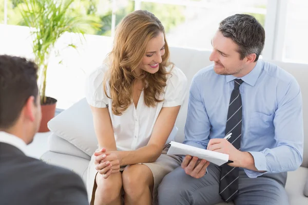 Lachende paar in gesprek met een financieel adviseur — Stockfoto