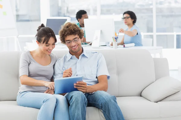 Couple utilisant une tablette numérique avec des collègues au bureau créatif — Photo