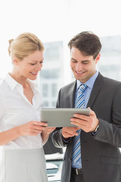 Lächelndes Business-Team schaut gemeinsam auf Tablet-PC — Stockfoto