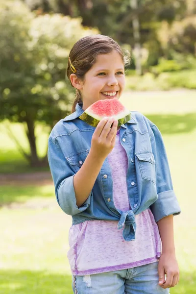 微笑着年轻女孩吃西瓜在公园 — 图库照片