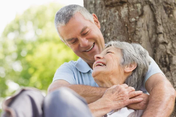 Senior umarmt Frau im Park von hinten — Stockfoto