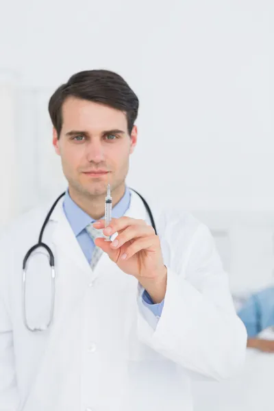 Bonito médico masculino segurando uma injeção — Fotografia de Stock