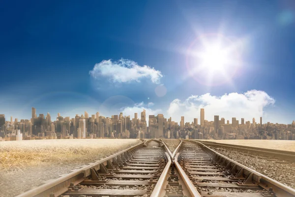 Trilhas de trem que levam à cidade sob o céu azul — Fotografia de Stock