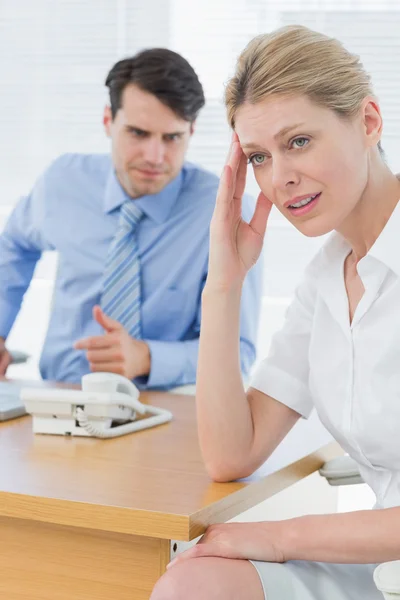 Upset businesswoman with man working on laptop — Stock Photo, Image