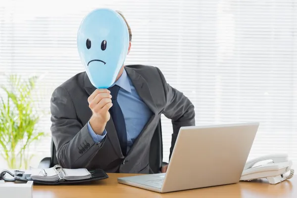 Empresário segurando triste sorriso enfrentou balão no escritório — Fotografia de Stock