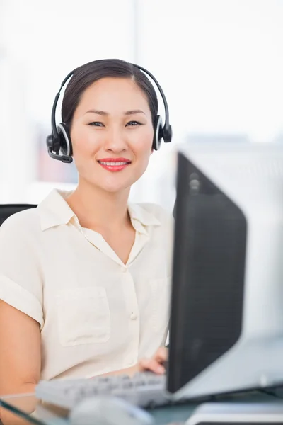 Ejecutiva femenina con auriculares usando computadora en el escritorio — Foto de Stock
