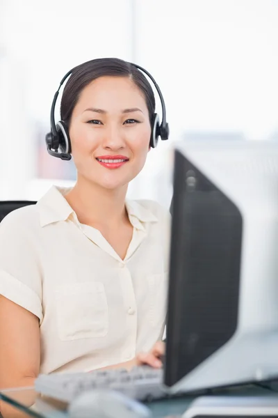 Femme exécutive avec casque à l'aide d'un ordinateur au bureau — Photo