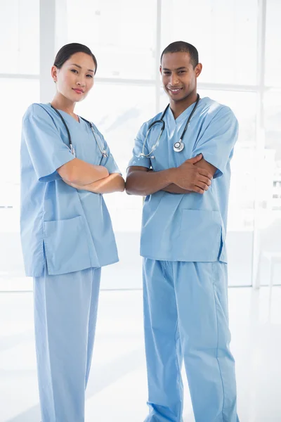 Selbstbewusste Chirurgen mit verschränkten Armen im Krankenhaus — Stockfoto