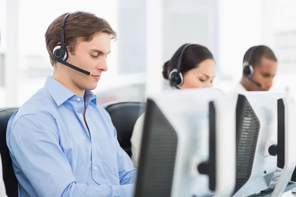 Geschäftskollegen mit Headsets nutzen Computer im Büro — Stockfoto