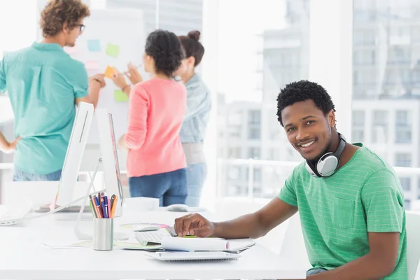 Casual man with group of colleagues behind in office — Stock Photo, Image