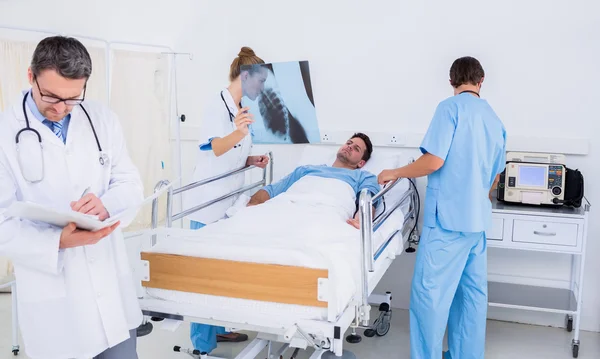Lékaři drží zprávy pacient v nemocnici — Stock fotografie