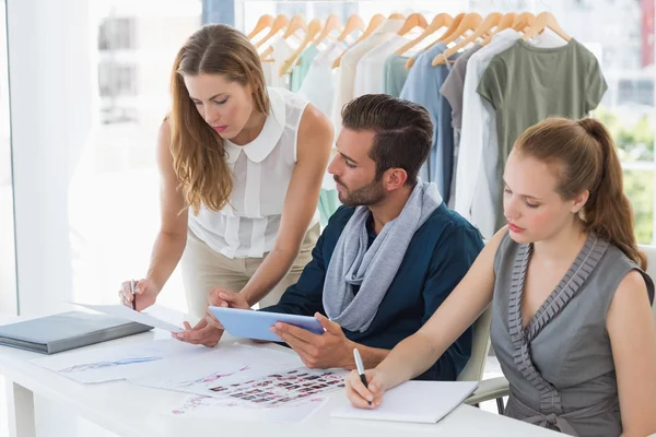 Tres diseñadores de moda discutiendo diseños — Foto de Stock