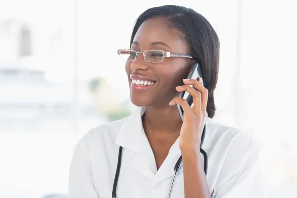 Lachende vrouwelijke arts met behulp van mobiele telefoon — Stockfoto