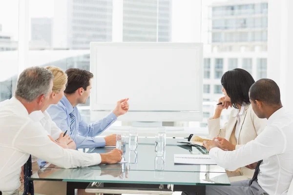 Mensen uit het bedrijfsleven kijken naar lege whiteboard in vergaderruimte — Stockfoto