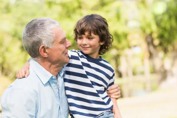 Grootvader en zoon glimlachend in het park — Stockfoto