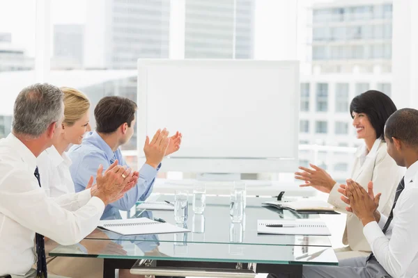 Geschäftsleute klatschen im Konferenzraum an leeres Whiteboard — Stockfoto
