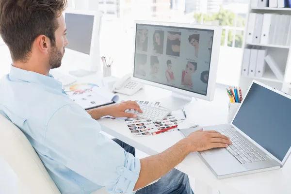 Parlak bir ofiste bilgisayar üzerinde çalışan erkek fotoğraf editörü — Stok fotoğraf