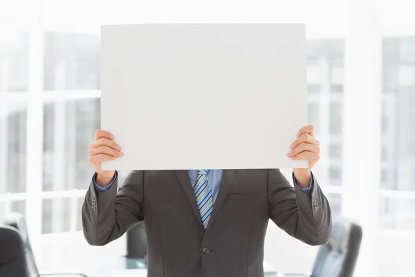 Empresário segurando cartaz sobre seu rosto — Fotografia de Stock