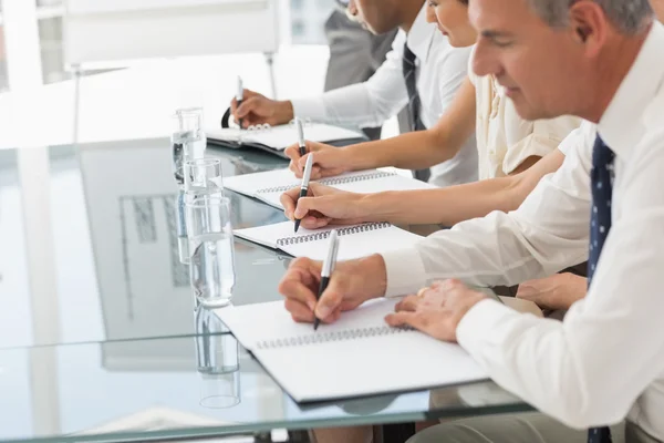 Geschäftsleute machen sich bei einem Treffen Notizen — Stockfoto