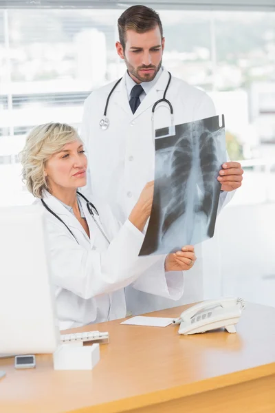 Médico femenino explicando radiografía a colega varón — Foto de Stock