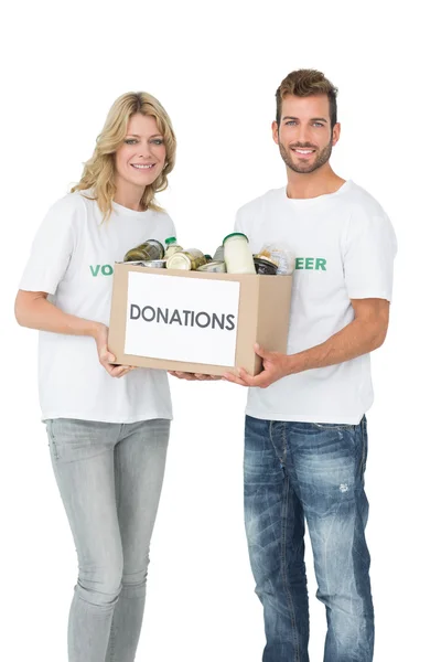 Sonriente joven pareja llevando caja de donaciones — Foto de Stock